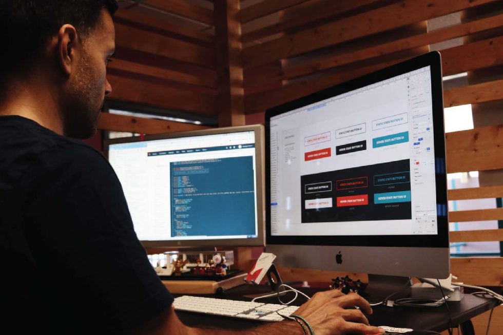 man looking at 2 monitor screen