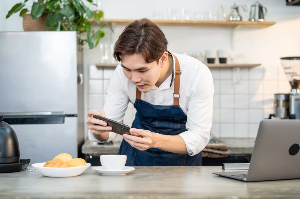 asian businessman cafe owner take photo of foods