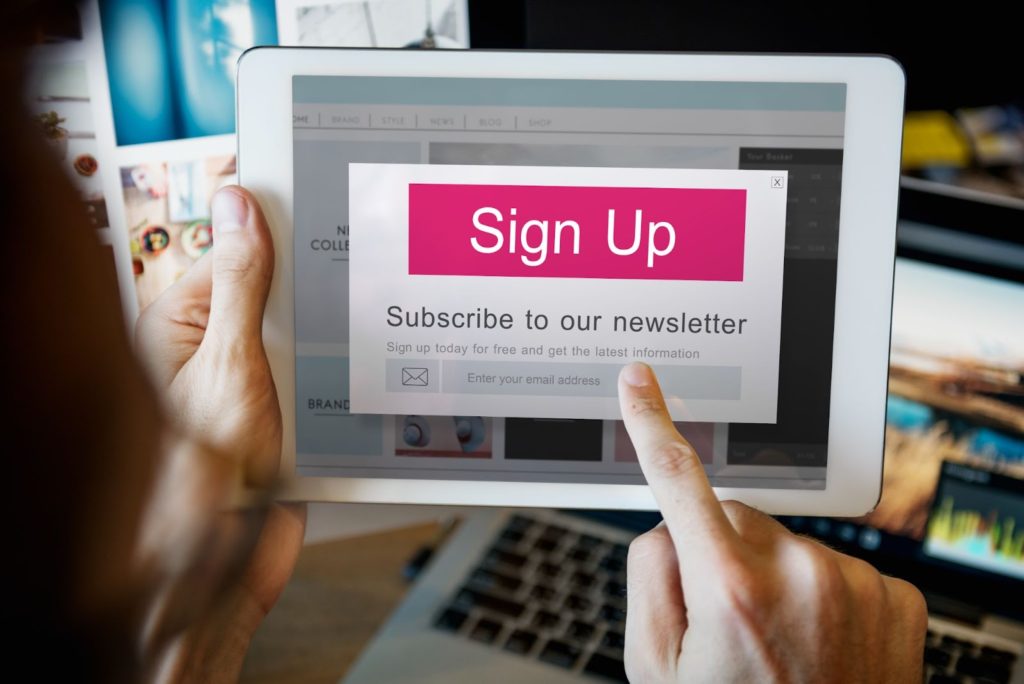 person is signing up to a newslatter using her ipad