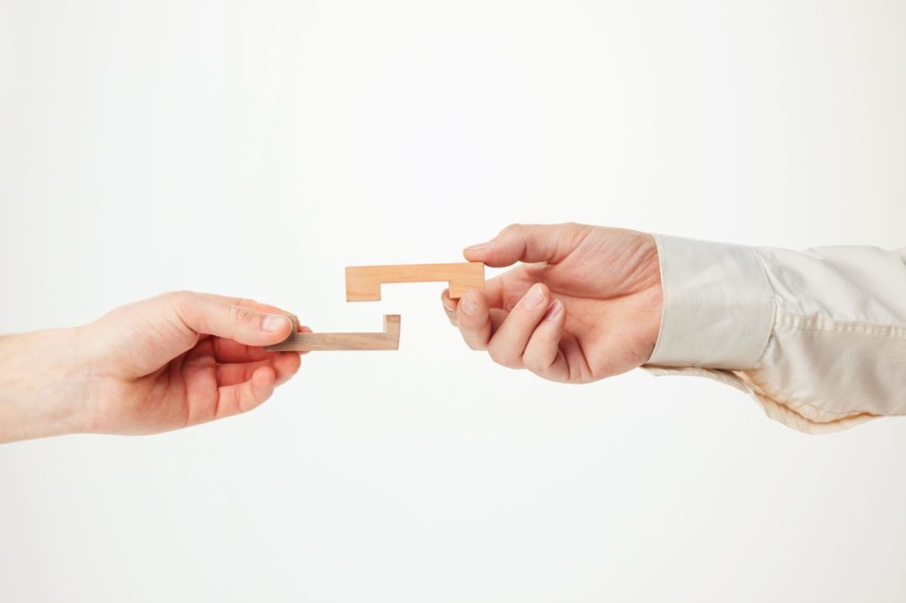 two hands holding wooden block